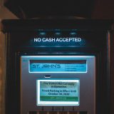 Parkeringsautomat med skilt "NO CASH ACCEPTED" og information om deaktivering.